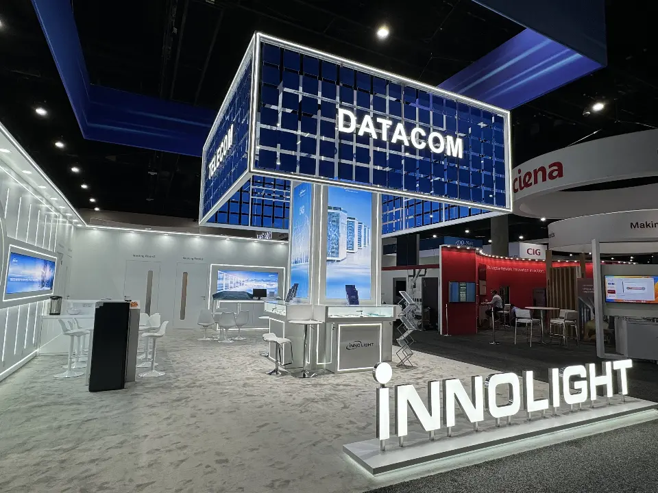 Blue grid DATACOM tower over glass showcases with lit INNOLIGHT letters in front