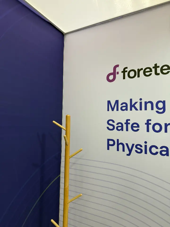 Corner panel of the Foretellix booth with the Making AI Safe tagline and a coat stand