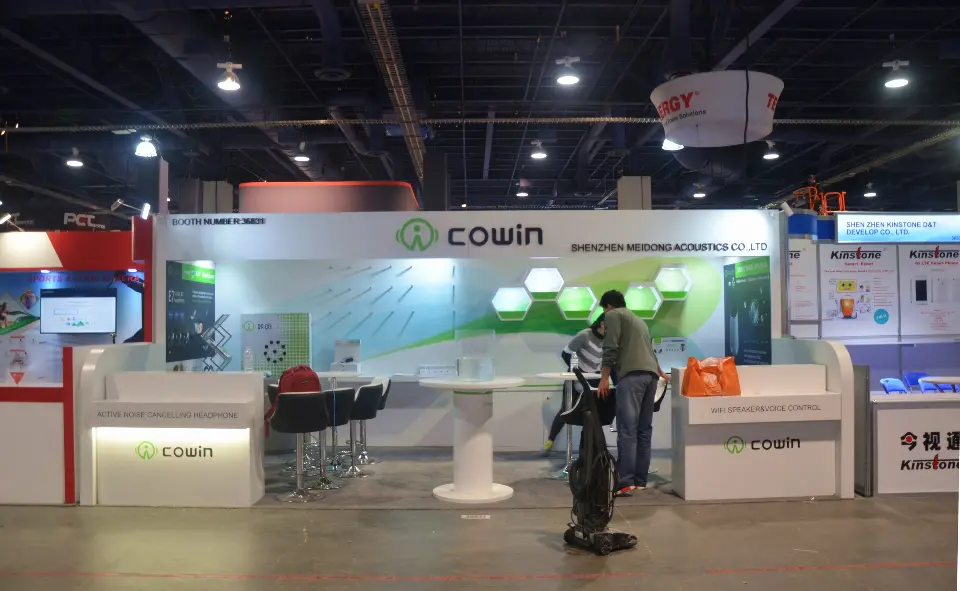 Second front angle of the Cowin booth with high tables and hexagon graphics