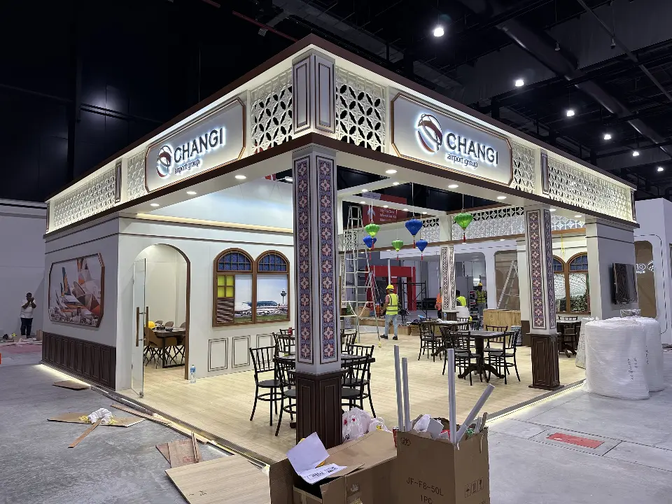 During build-up: CHANGI corner with lattice fascia, café tables and wood-look base