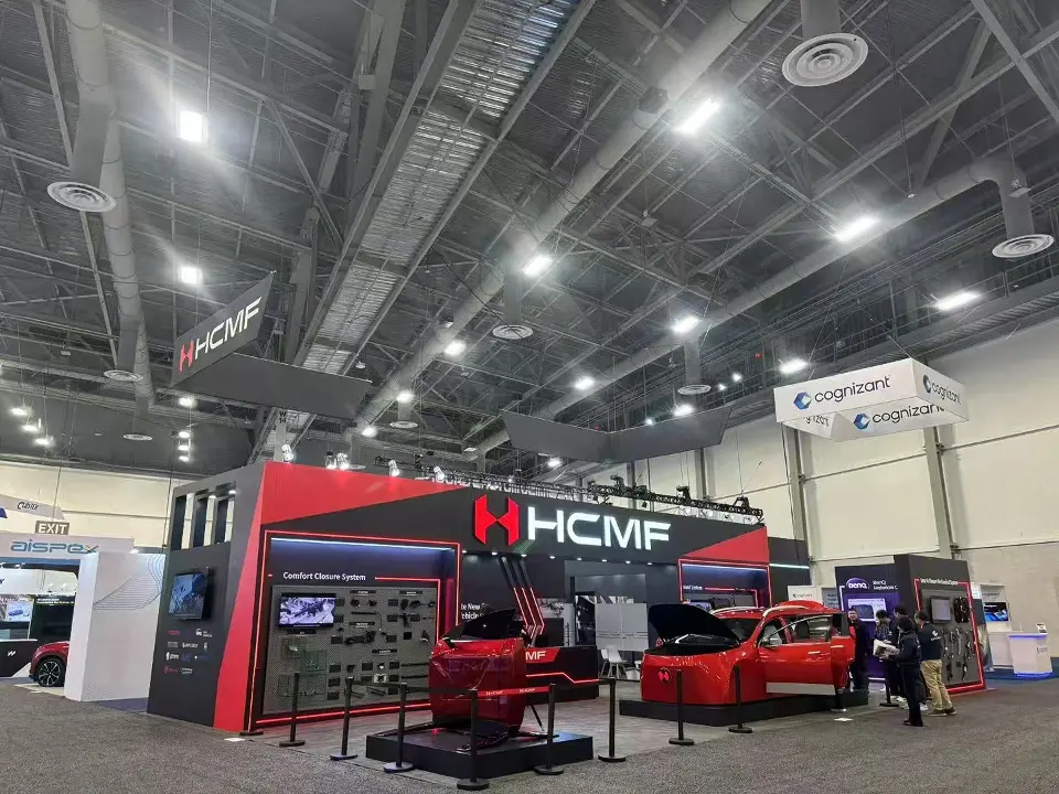 Wide view of the black and red HCMF booth with red vehicles on display