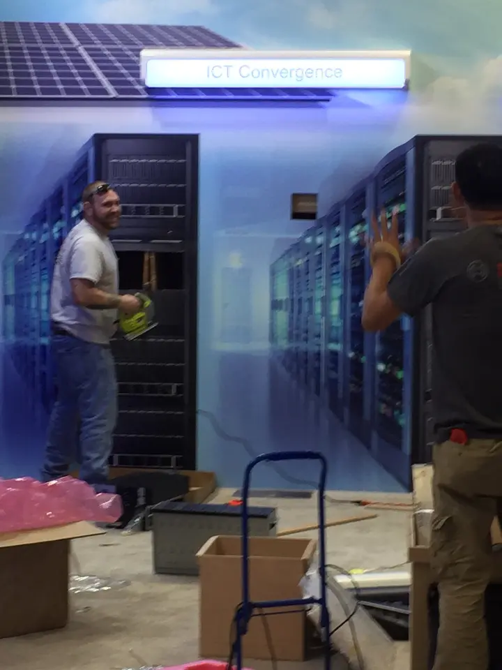 During installation: worker by the server racks with a hand truck in the foreground