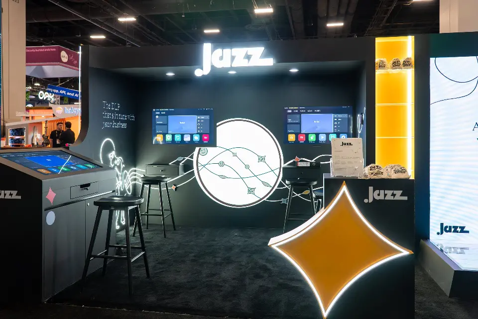 Interactive table and stools inside the Jazz booth beside the backlit gold star