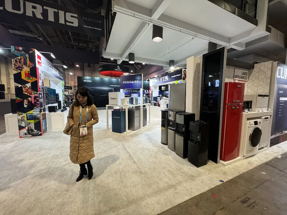 Visitor beside a red retro fridge and white appliances on the back wall