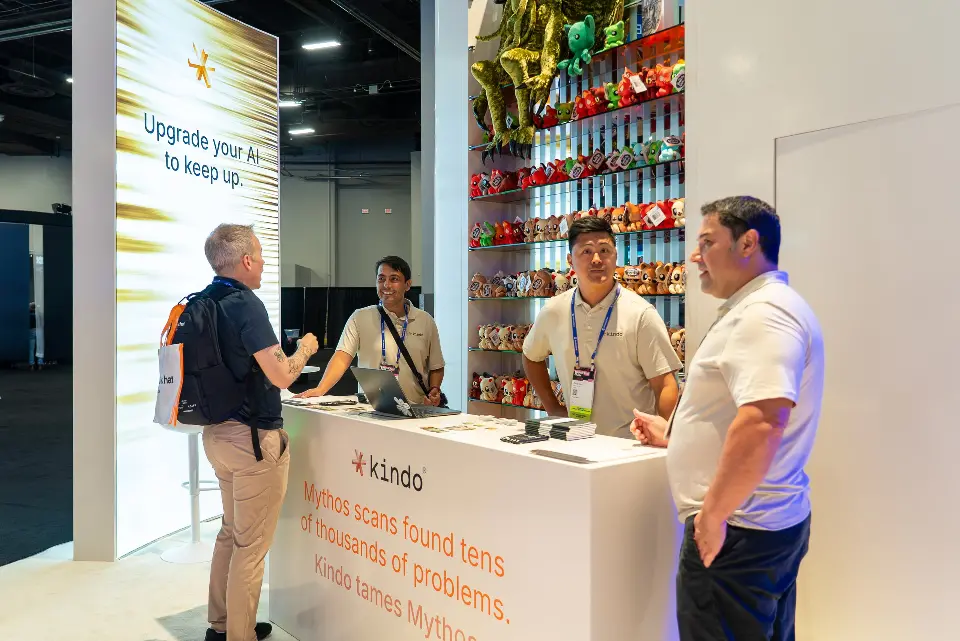 Staff and visitors talking at the white kindo counter beside a backlit message tower