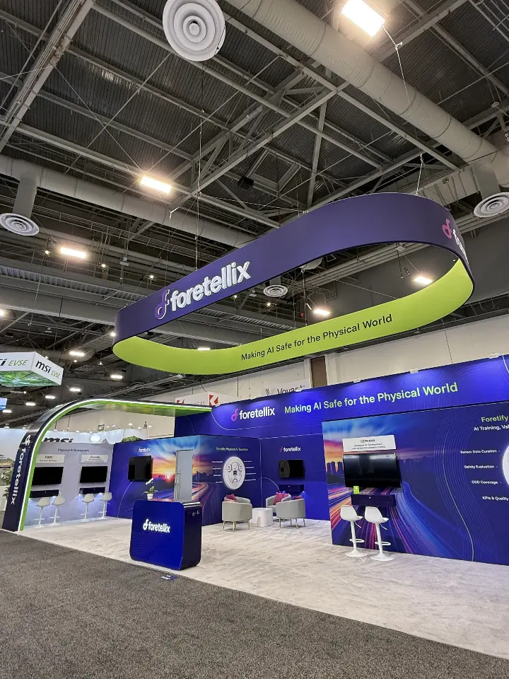 Lime-green curved ring framing the navy booth walls and demo screens below