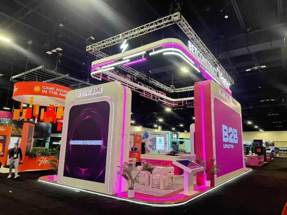 Rear corner of the stand with pink screen tower and lit truss frame