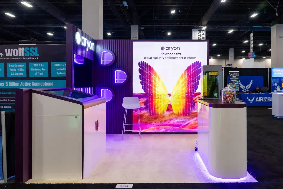 Open front of the Aryon booth showing the full wing graphic and a white stool