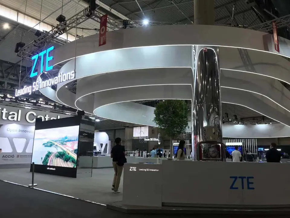 Mirrored column and ring canopy beside a large display screen
