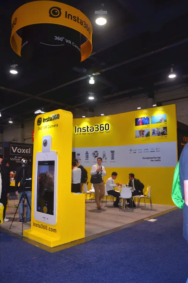 Yellow display tower with screen below the round hanging sign, portrait view