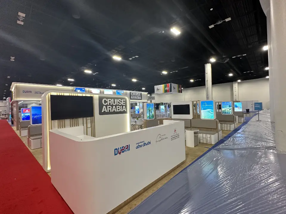 Side reception counter with Dubai logo seen from the red-carpeted aisle