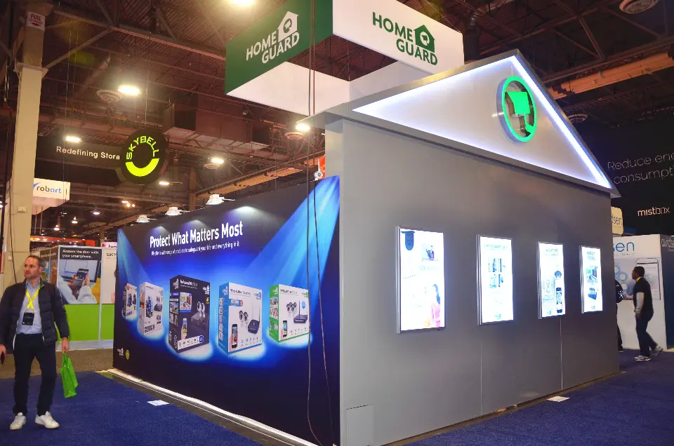 Silver side wall of the Home Guard booth with four lightboxes and Protect What Matters Most graphic