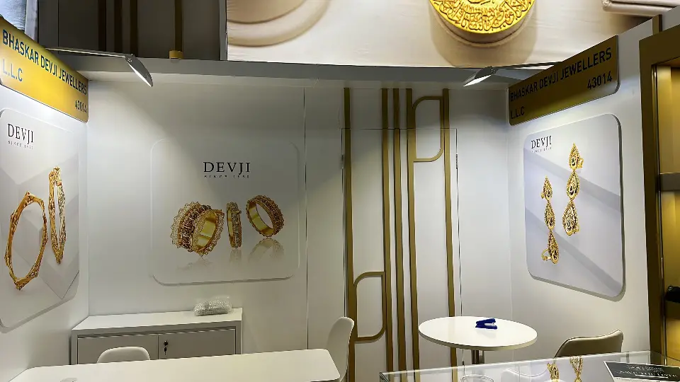 Devi exhibitor bay with gold jewelry images on a white wall