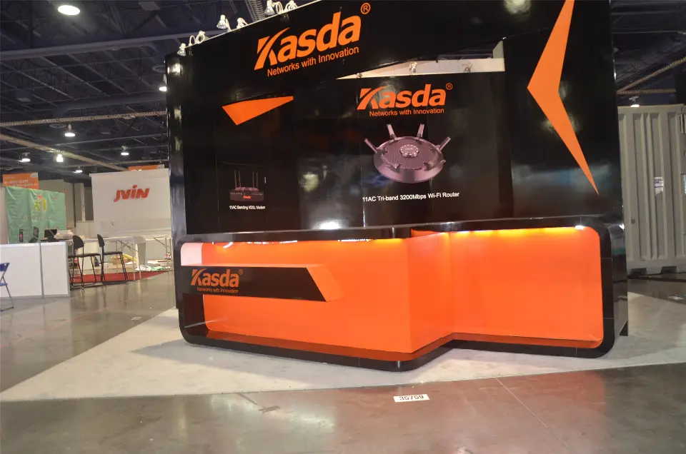 During build-up: front of the Kasda booth with router graphic and stepped orange counter