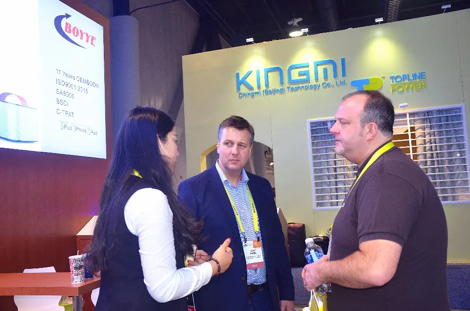 Two visitors in conversation with staff beside the counter