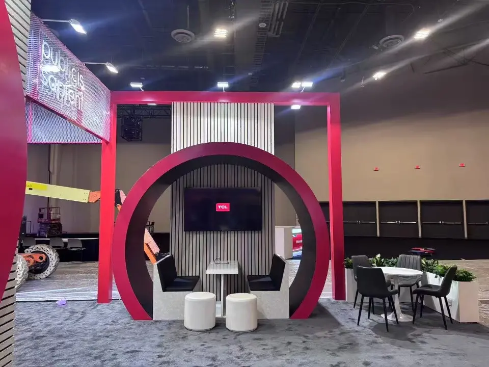 Red ring pod framing a wall screen with white seats and side tables