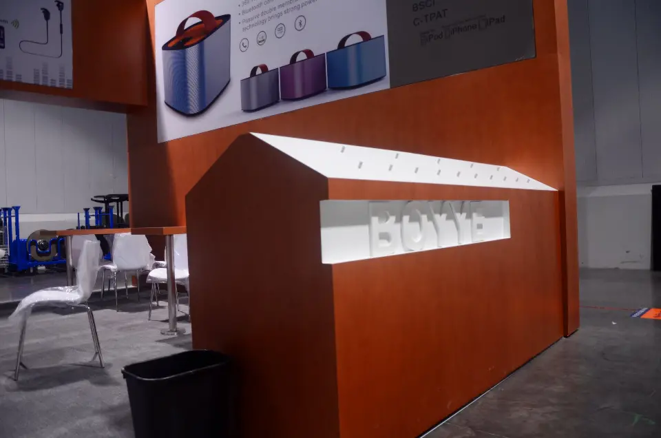 Close angle of the house-shaped display stand in front of the speaker graphic