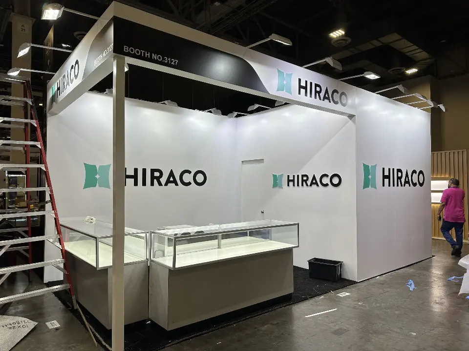 Front view of glass jewelry showcases under white walls and dark curved header