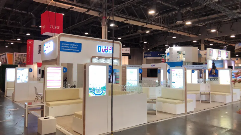 Wide view of the Dubai stand with lightboxes and a red hanging drum above