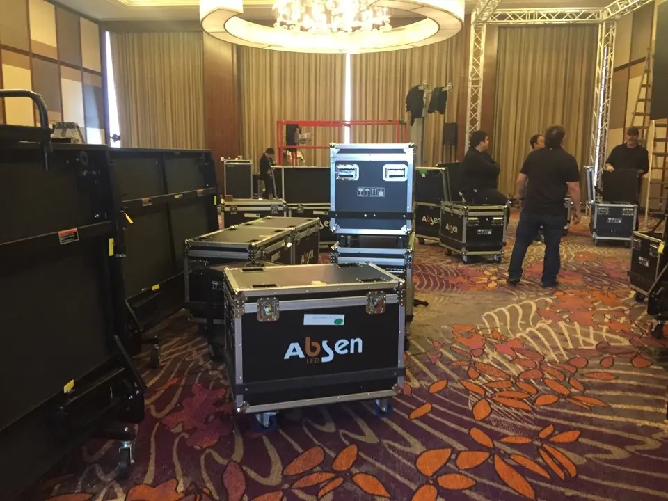 Ballroom floor with road cases, truss parts and crew starting the stage setup