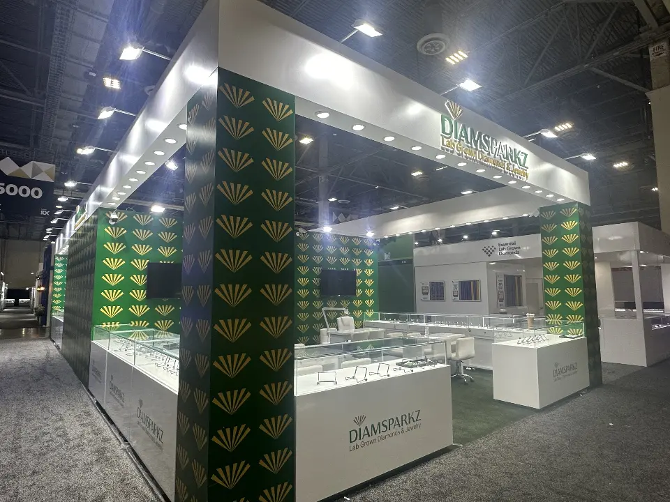 Long side of the booth with lit header and a row of showcases