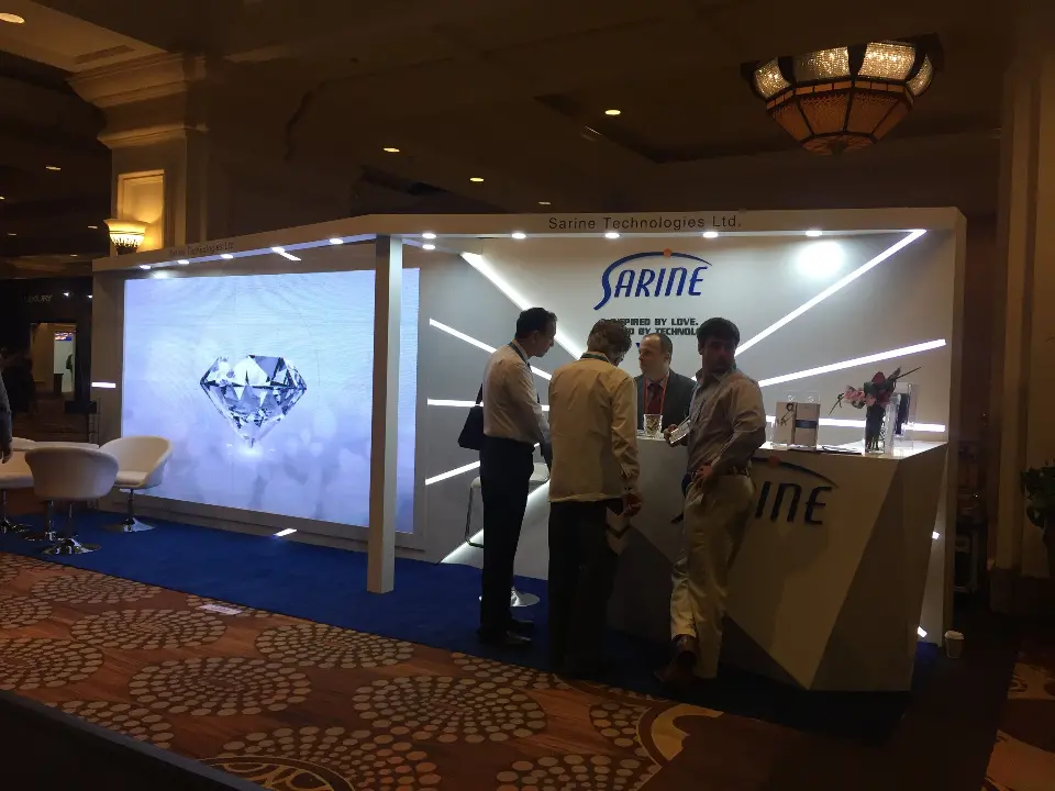 Show-day view of visitors at the faceted counter beside the diamond video screen