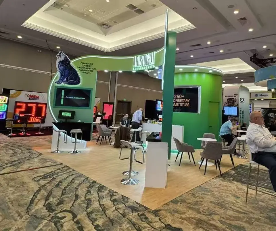 Side of the Aristocrat Interactive booth with a 250+ proprietary game titles screen and white bar seating