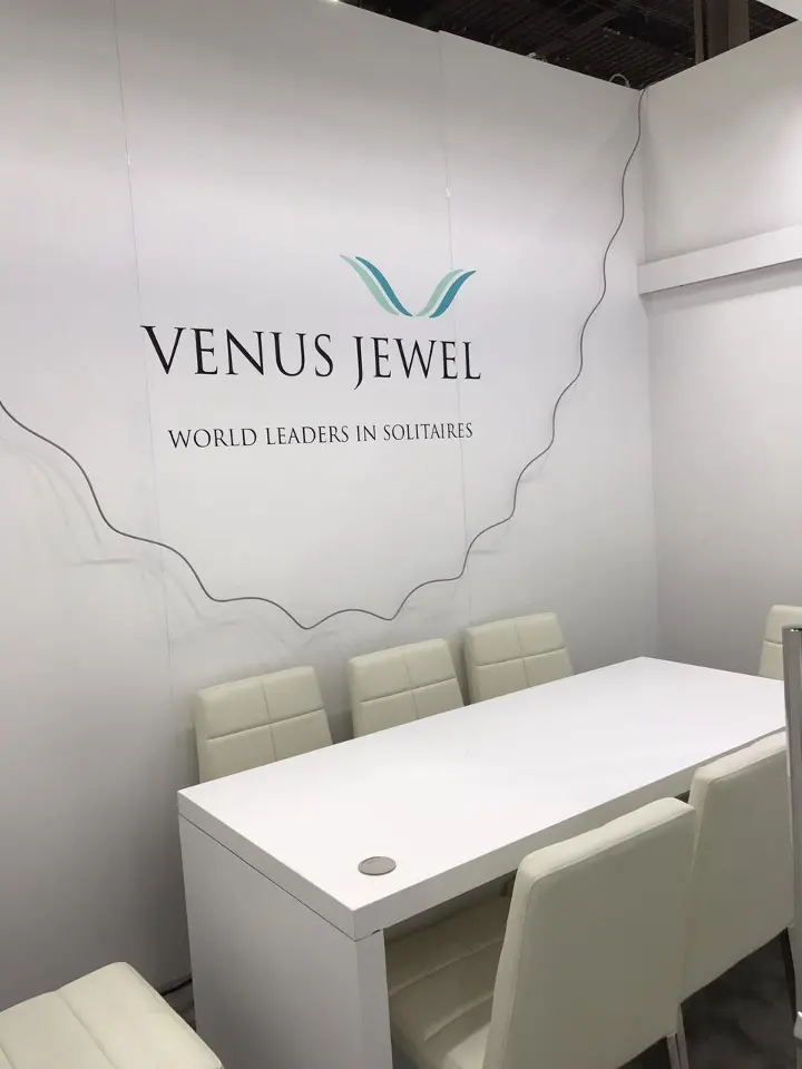 Smaller white meeting room with a white table and the Venus Jewel logo