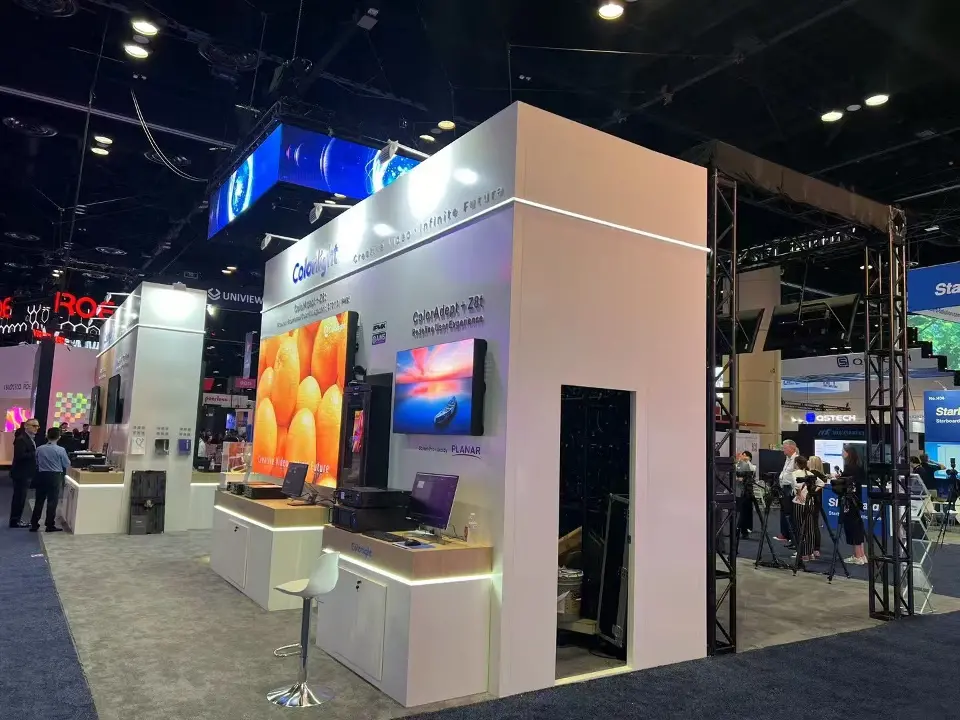 Side view of the Colorlight stand showing a white storage room, product demo counters and wall-mounted displays