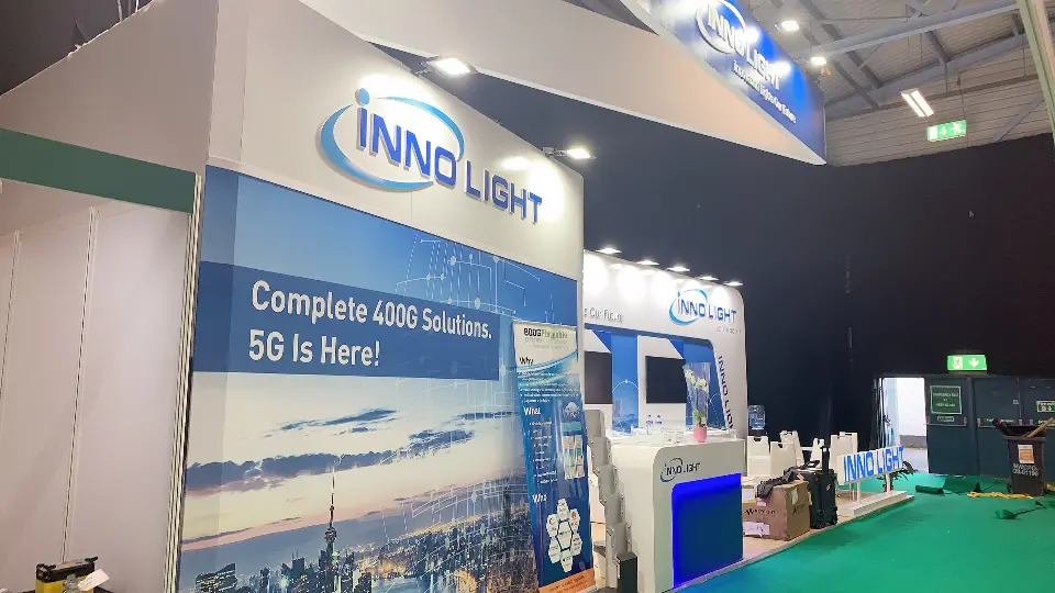 End wall of the InnoLight booth with skyline graphic and green carpet edge