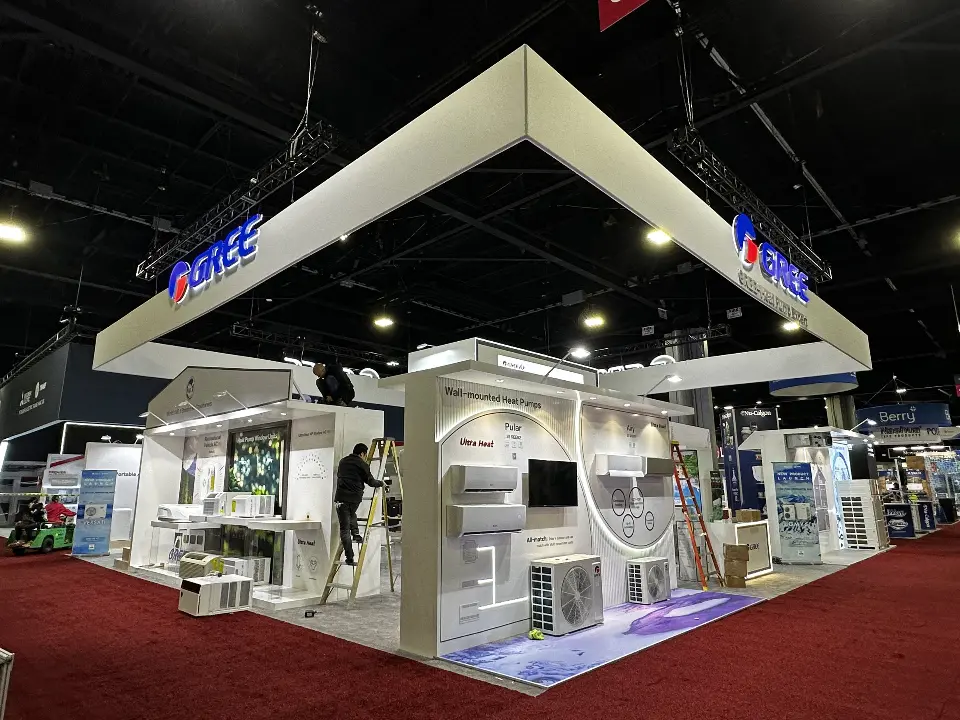Finished GREE booth on red carpet with white display walls under the square header