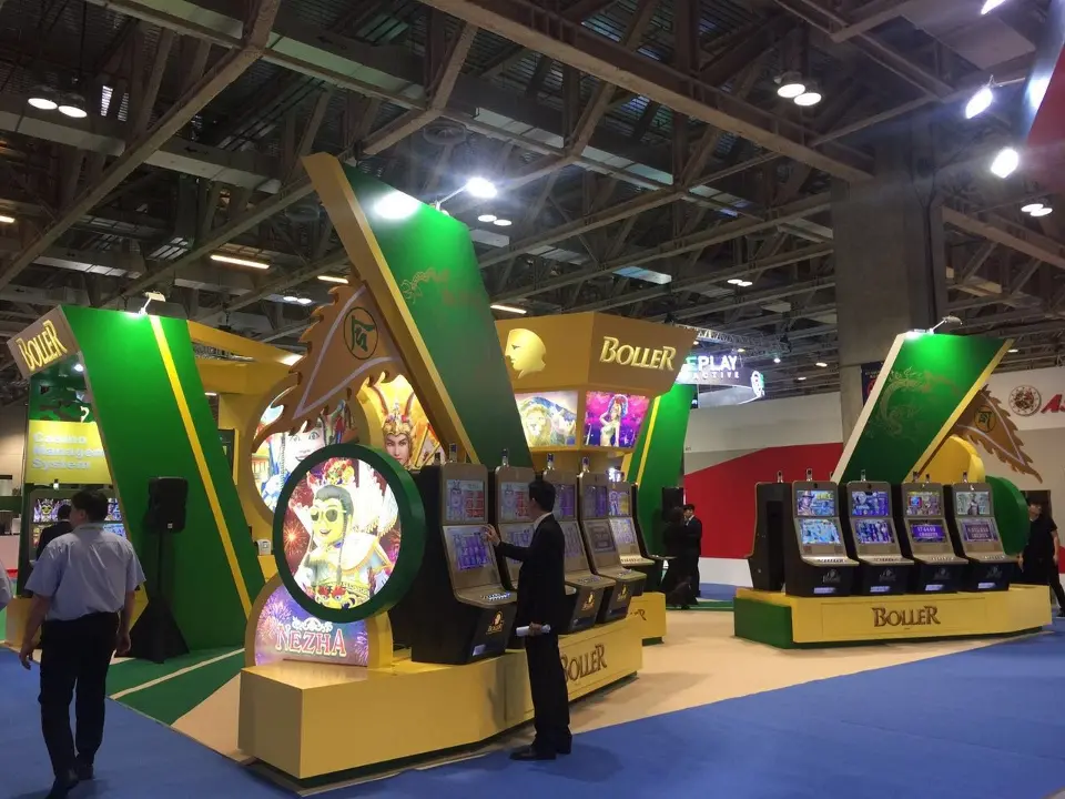 Wide view of the booth corner with machines, emblem and green carpet