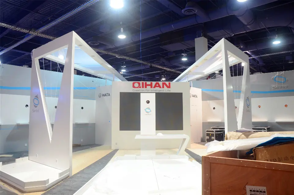 During build-up: white angular portals around a dark panel wall with red QIHAN logo