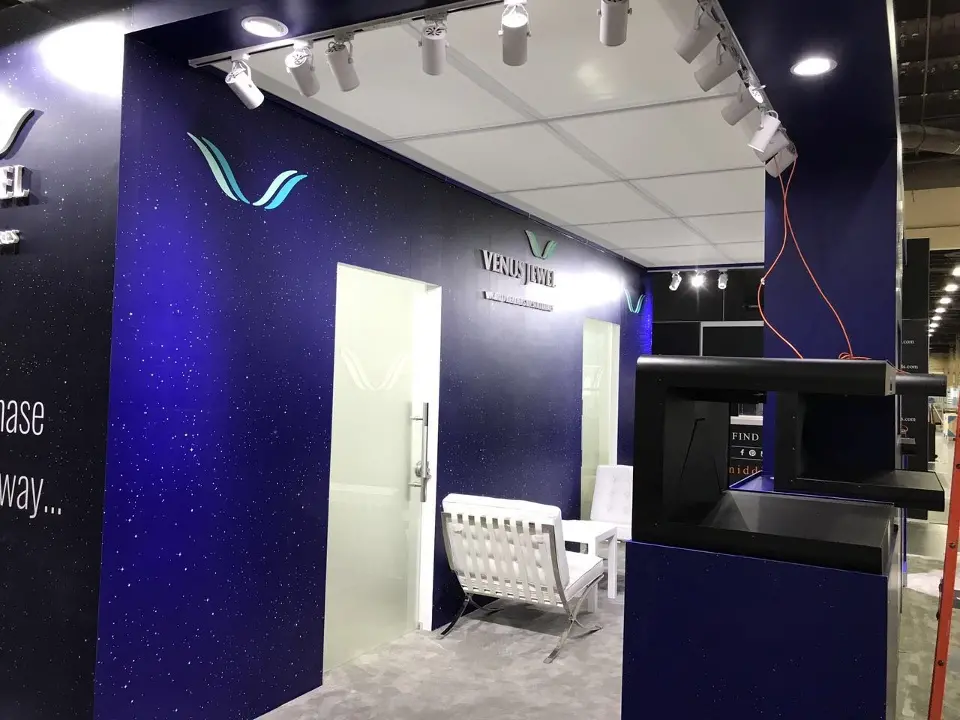 Open bay with V logo, track lighting and a white leather chair