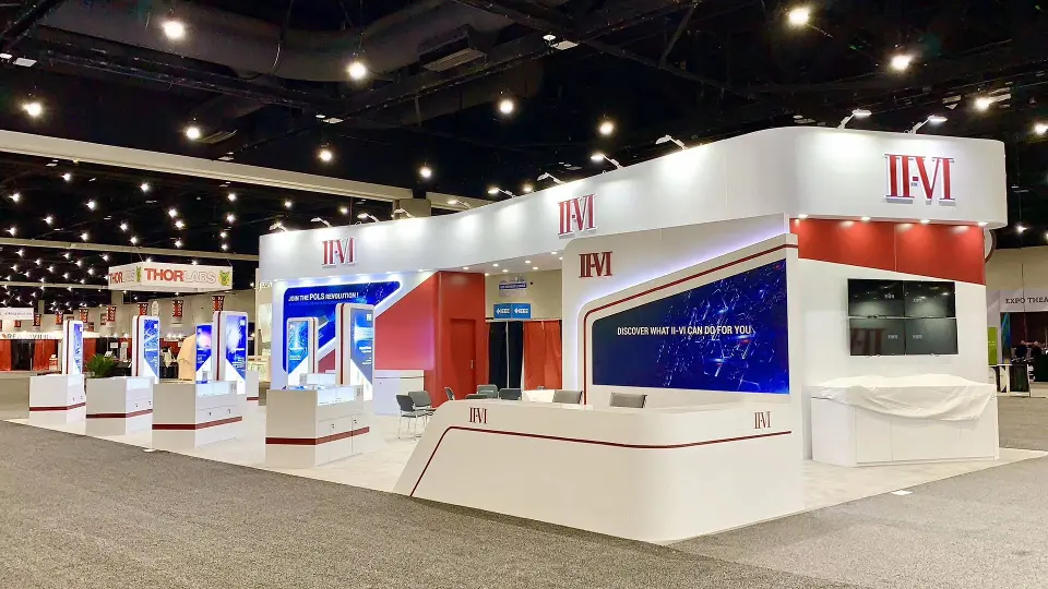 Finished front of the booth with white counter, red fascia and screens