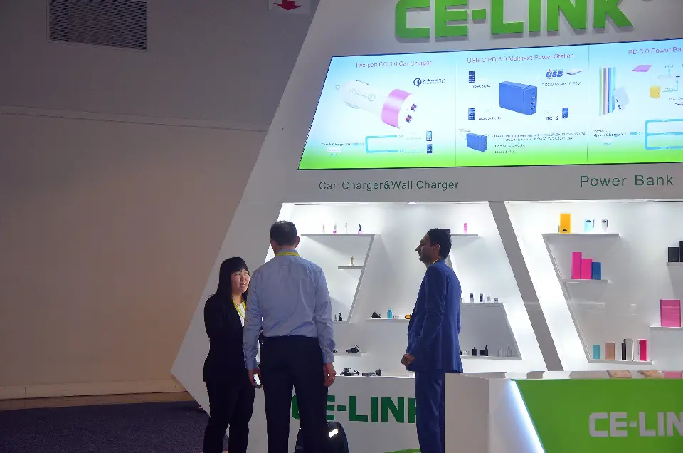Visitors talking beneath a large backlit CE-LINK graphic