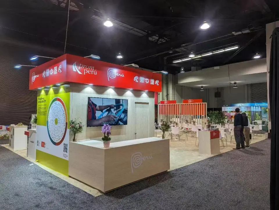 White reception counter and video screen under the red Peru header