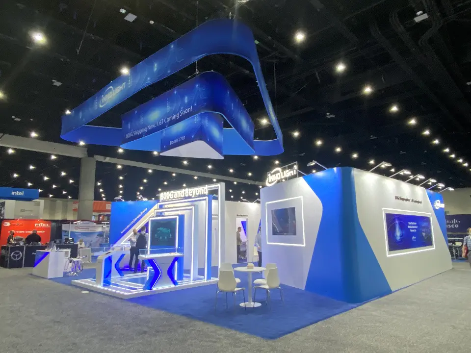 Corner view of the InnoLight booth with the blue frame suspended above white walls