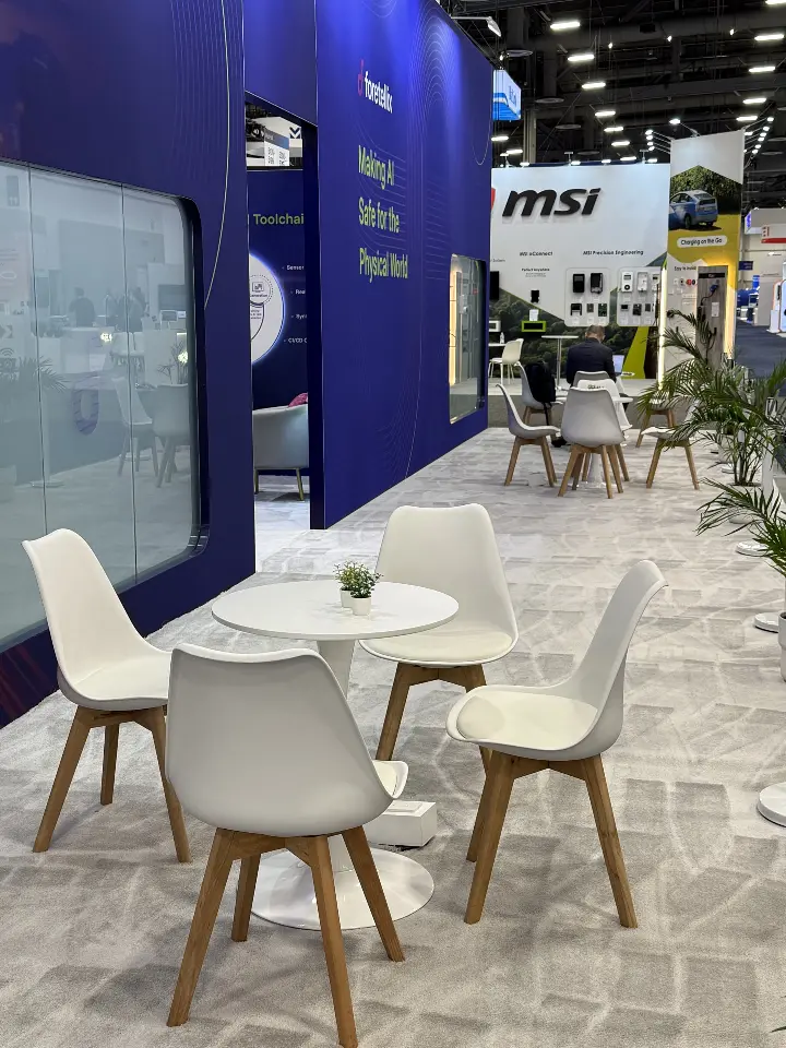 White cafe chairs and round tables beside a frosted glass room wall
