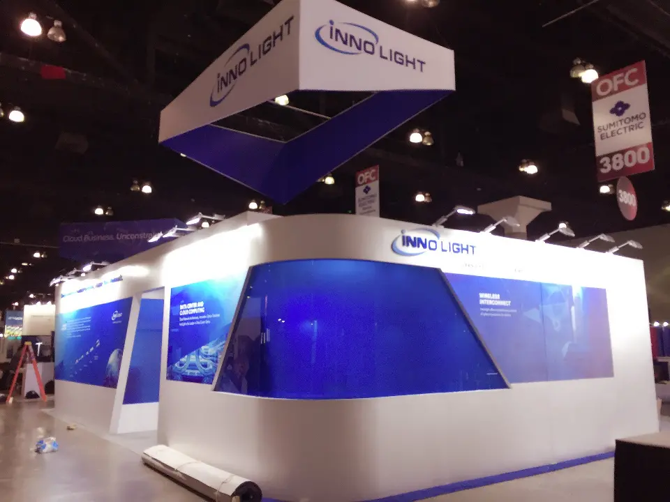 Curved blue glass panel running along the white booth wall