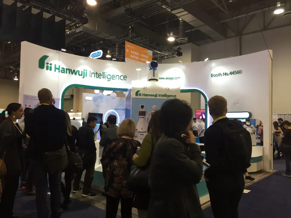 Crowd gathered in front of the Hanwuji booth under the curved teal fascia
