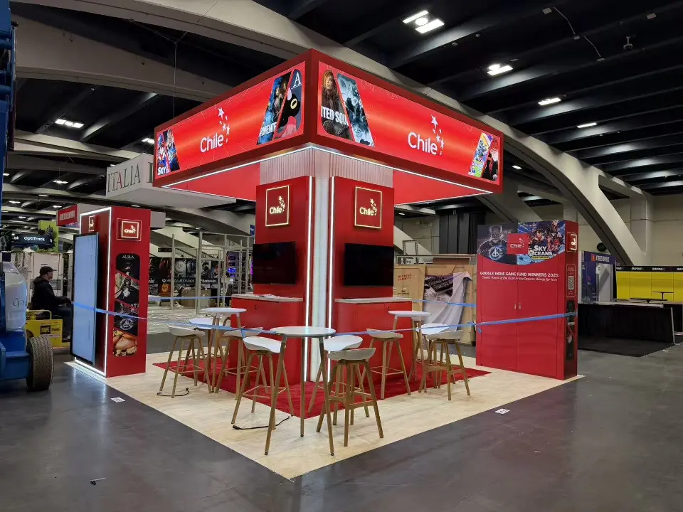 Corner view of the red pavilion with backlit game-art header and high tables