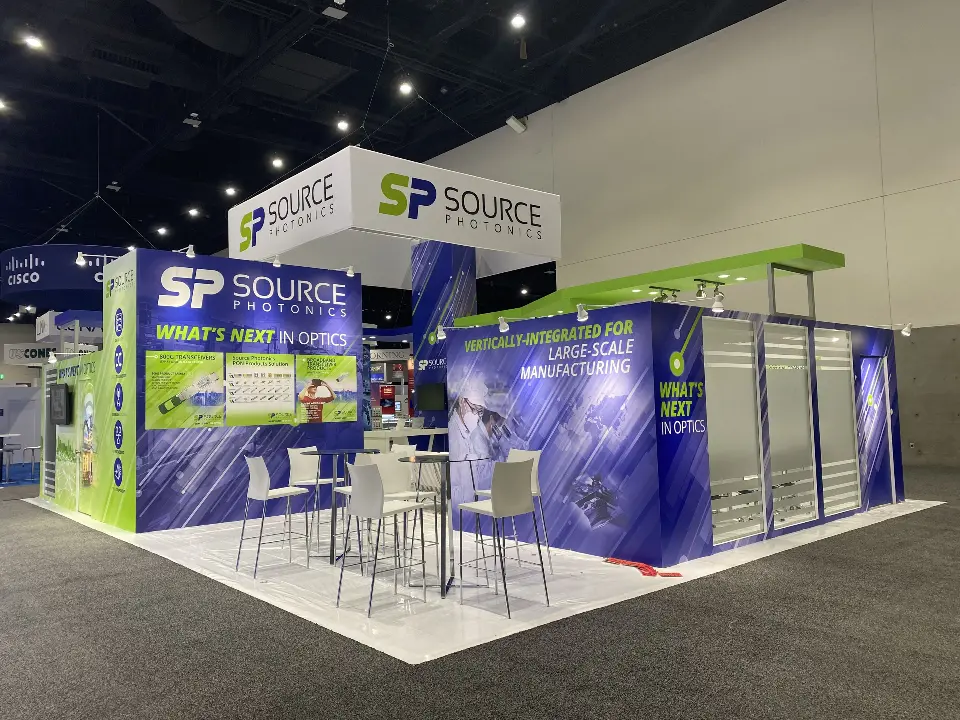Finished Source Photonics corner with purple printed walls, green canopy and white bar stools