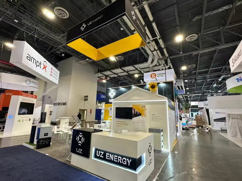 UZ Energy stand seen from the corner, with lit UZ Energy reception counter beneath the yellow header