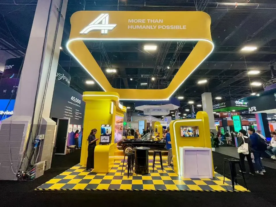 Corner of the Advantage booth with the lit yellow frame overhead and the fuel-pump pillar