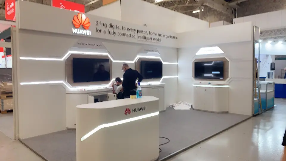 Side view of the back wall with two framed screens and a white bar table