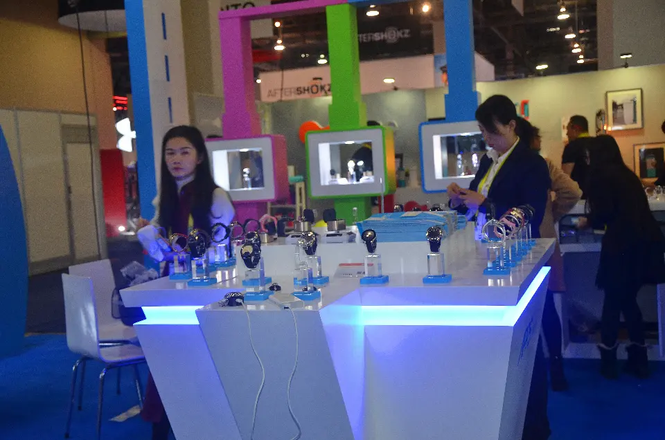 White APPScomm counter with a blue-lit band holding smartwatches on clear stands