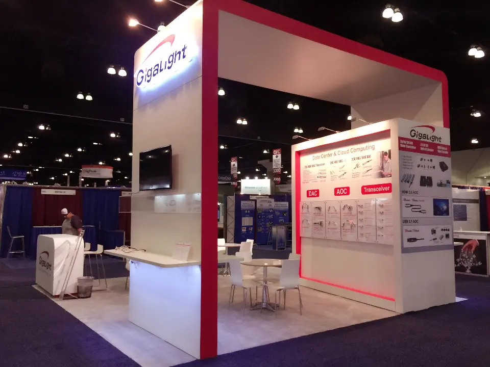 Gigalight open booth with red-edged frame, wall-mounted screen and white meeting table