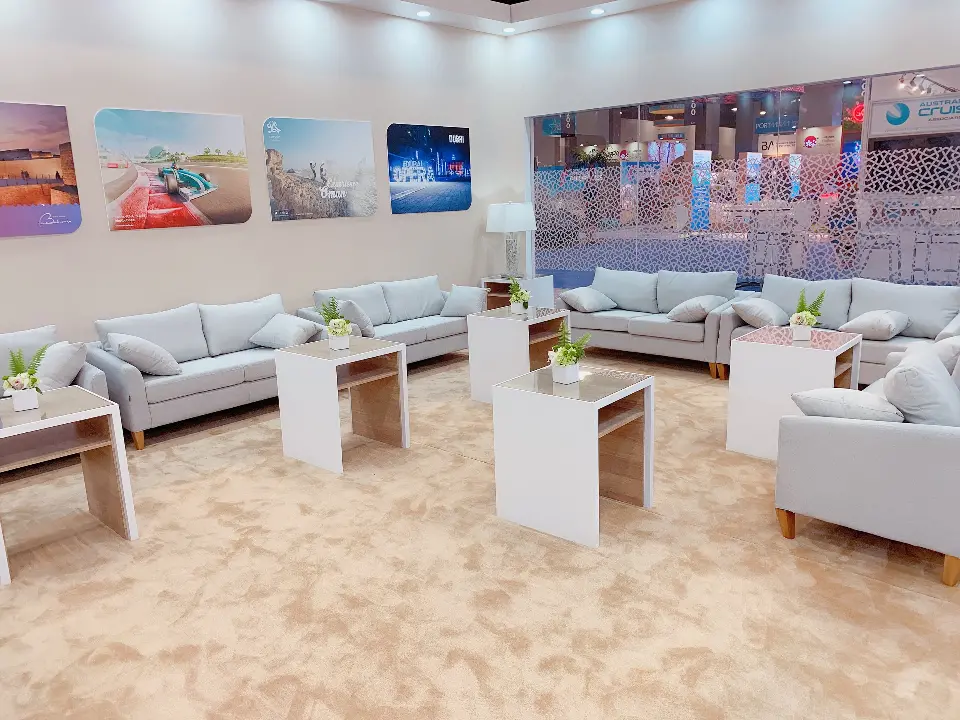 Lounge area with grey sofas, white tables and framed photos