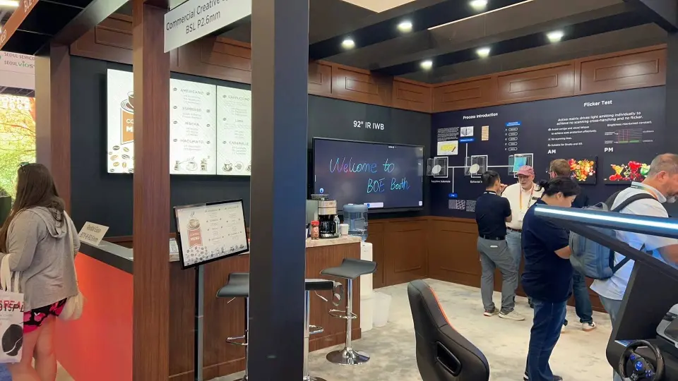 Visitors at an interior counter with framed product displays on wood-look walls
